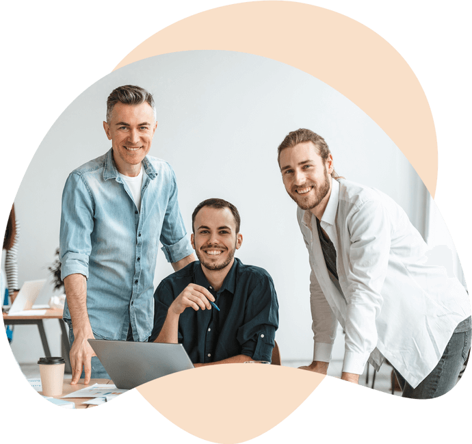 a group of men smiling at a laptop