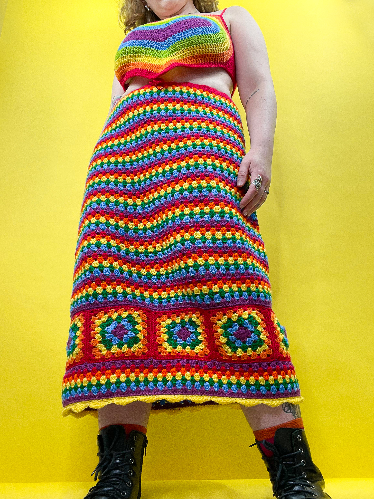 a woman wearing a rainbow crochet skirt