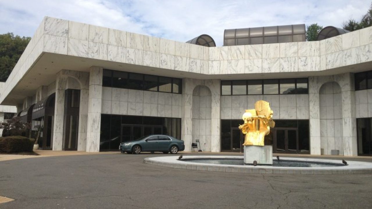 a building with a fountain and cars parked in front of it