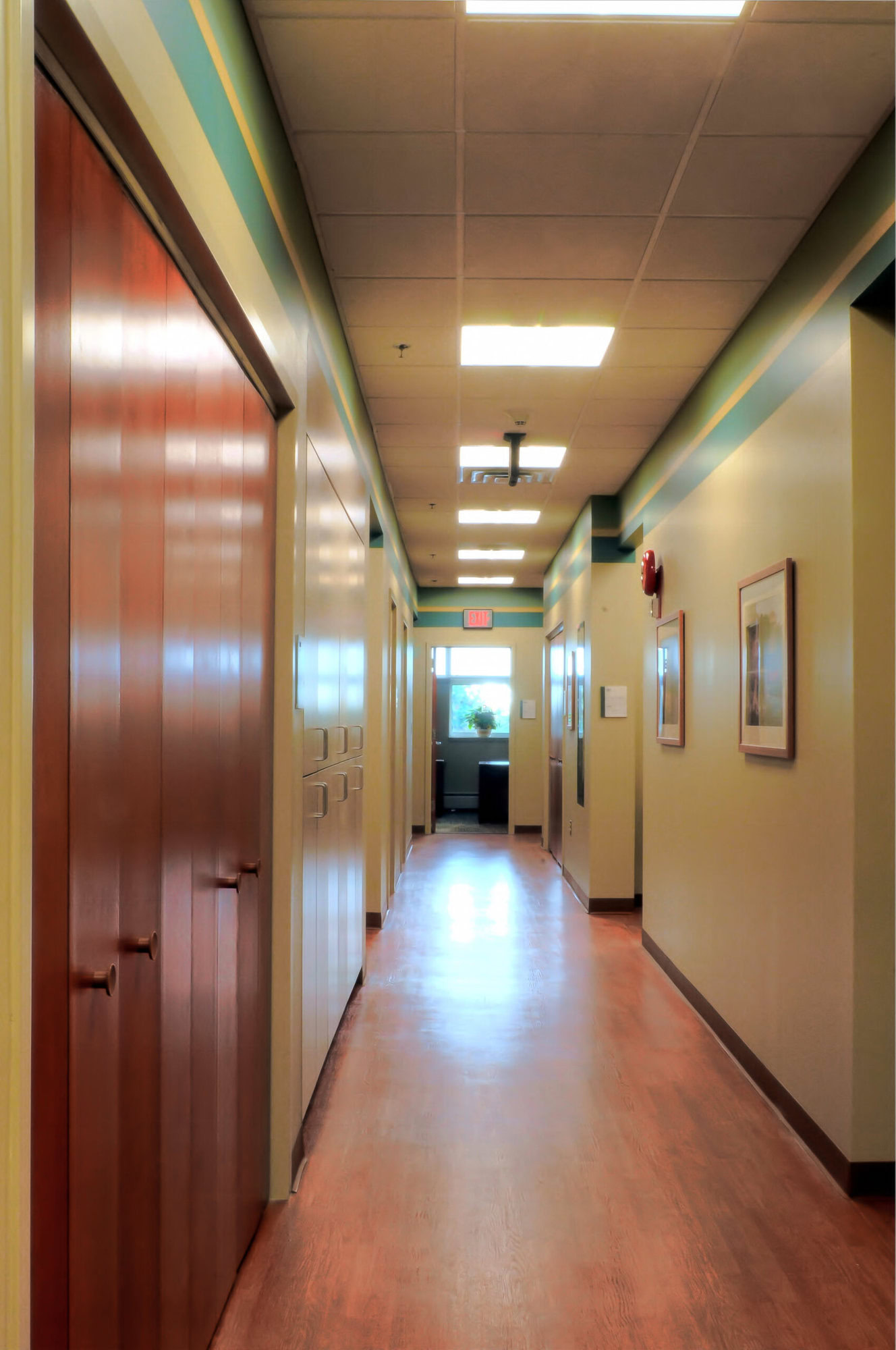 a long hallway with doors and a wood floor