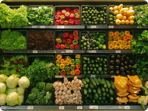 a shelf of vegetables and fruits