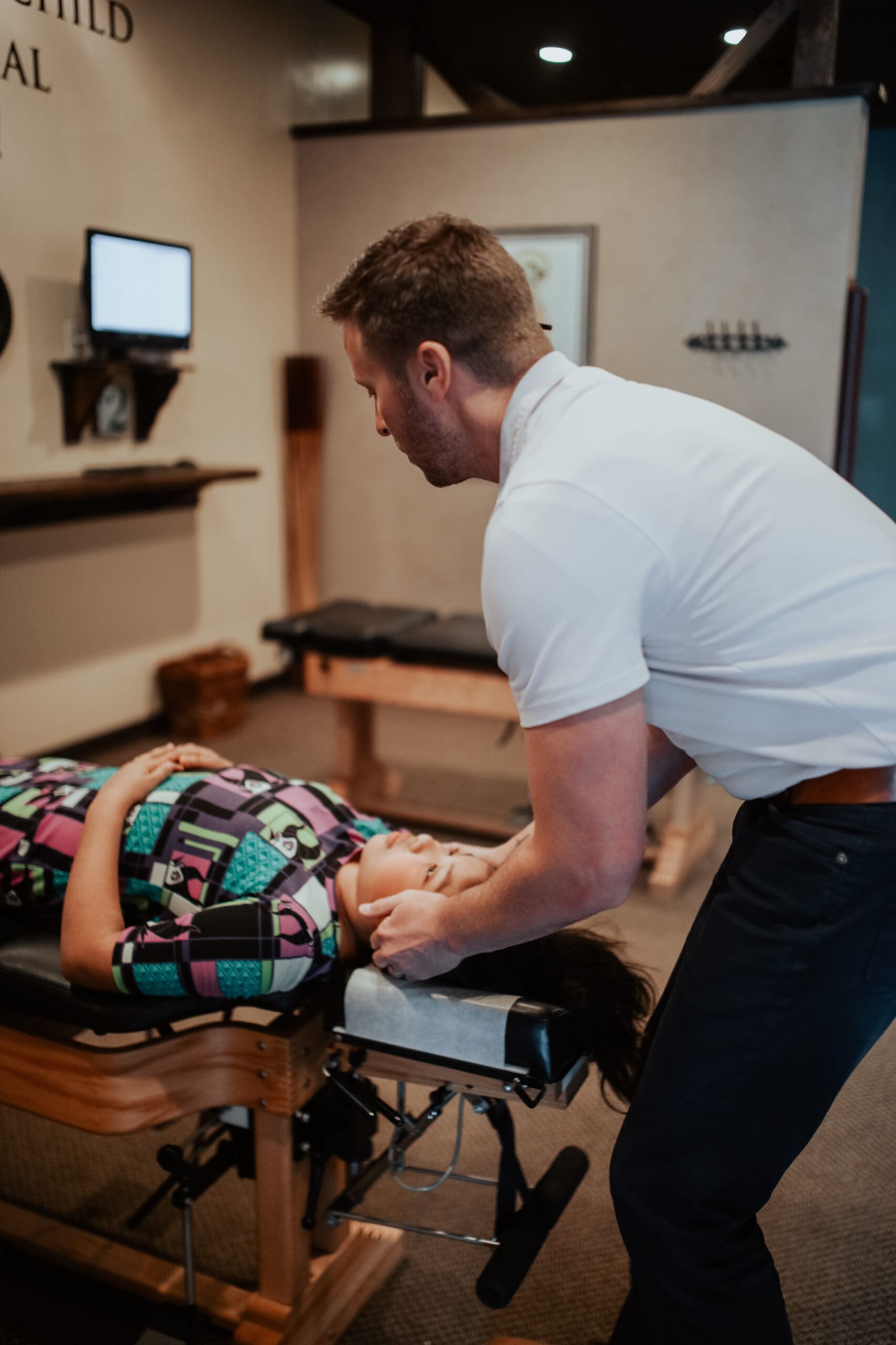 a man standing next to a woman lying on a massage table