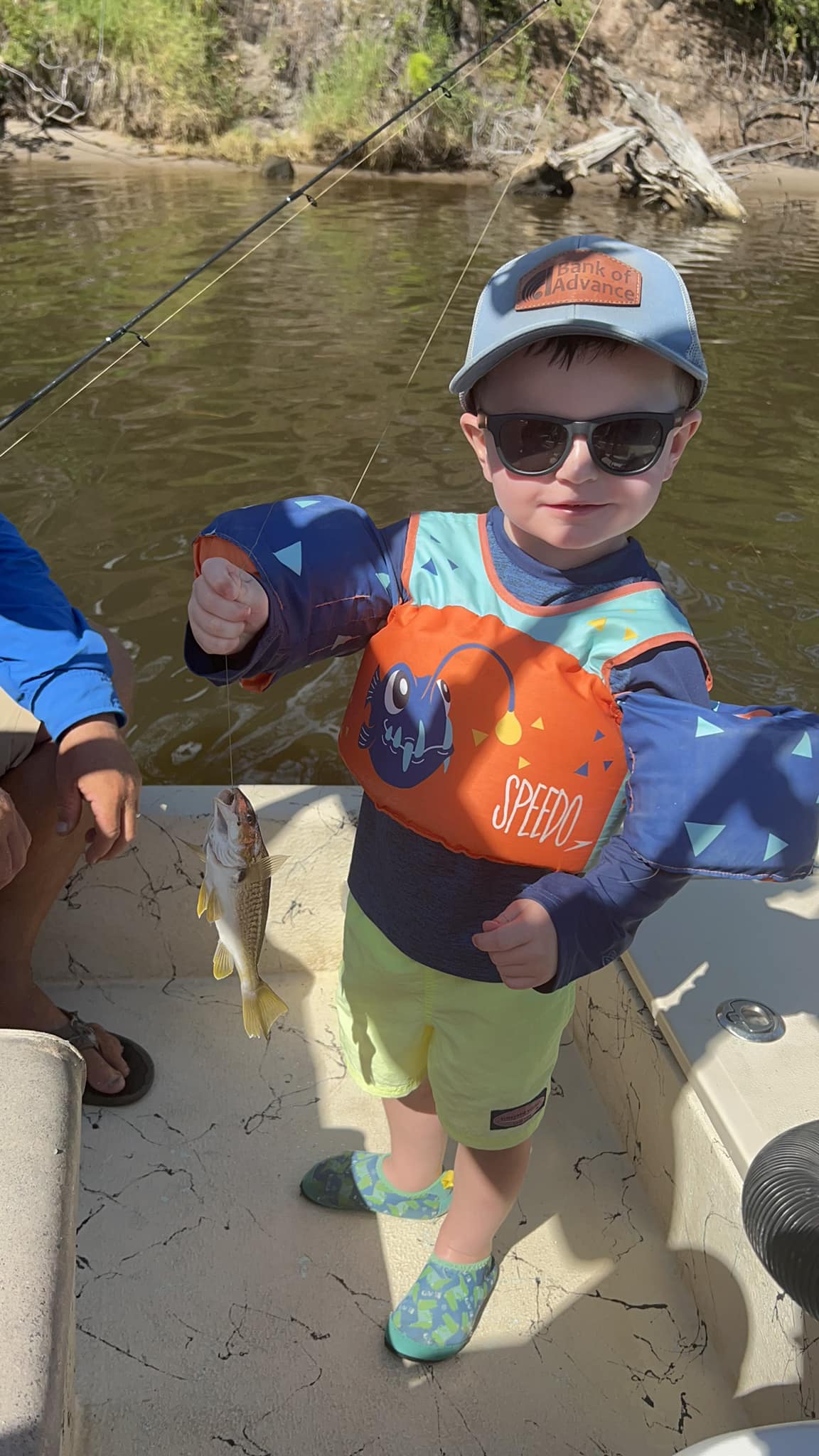 a boy holding a fish in a boat