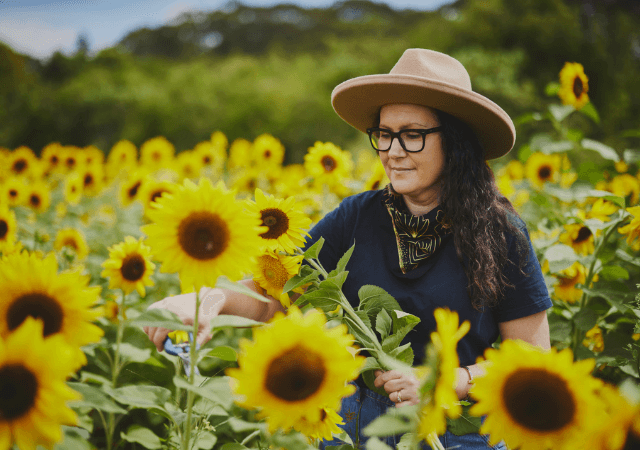 a woman in a hat in a field of sunflowers