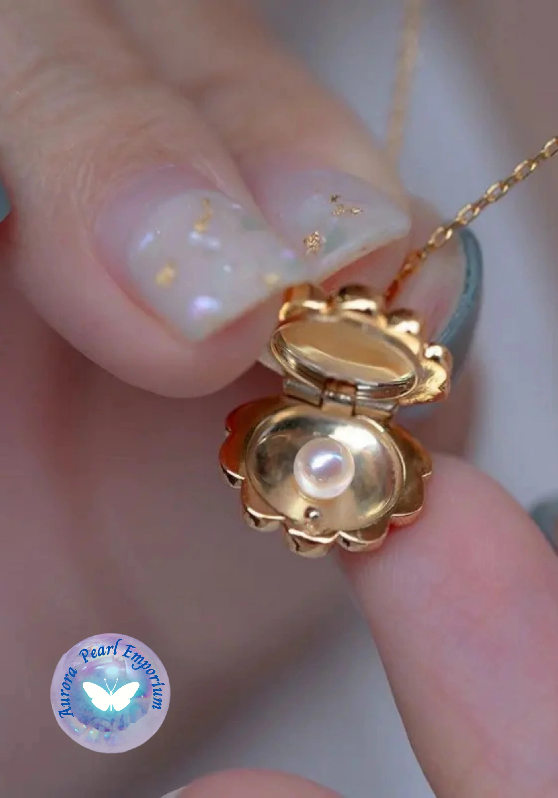 a person holding a gold necklace with a pearl in it