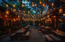 a group of tables and benches with lights from trees