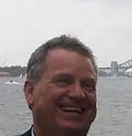 a man smiling in front of water