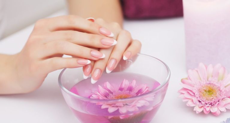 a woman's hands with french manicure and a bowl of water