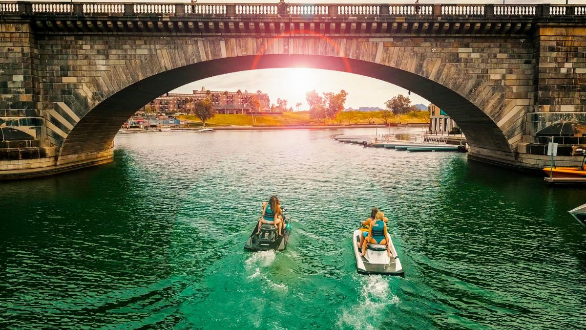 a group of people on pedal boats on water under a bridge