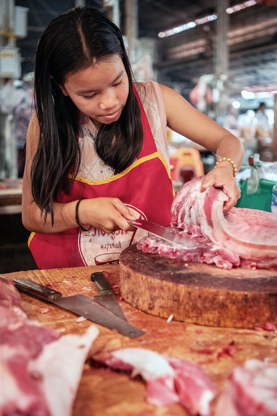 a woman cutting meat on a cutting board