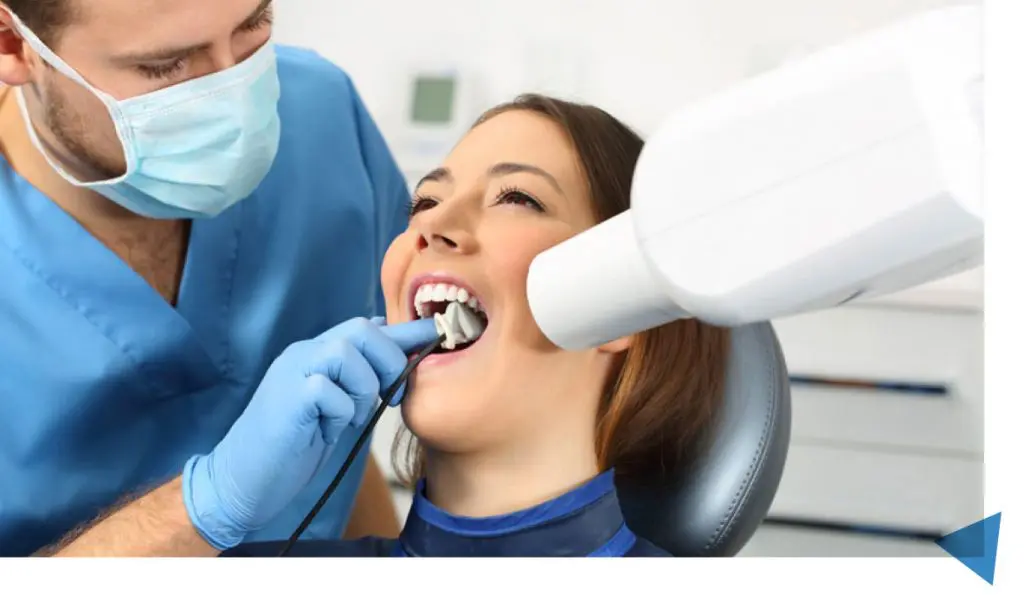 a dentist examining a woman's teeth