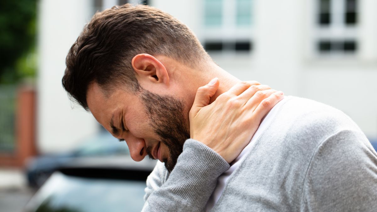 a man holding his neck and shoulder