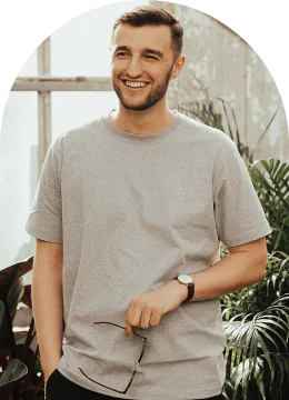 a man smiling in a grey shirt