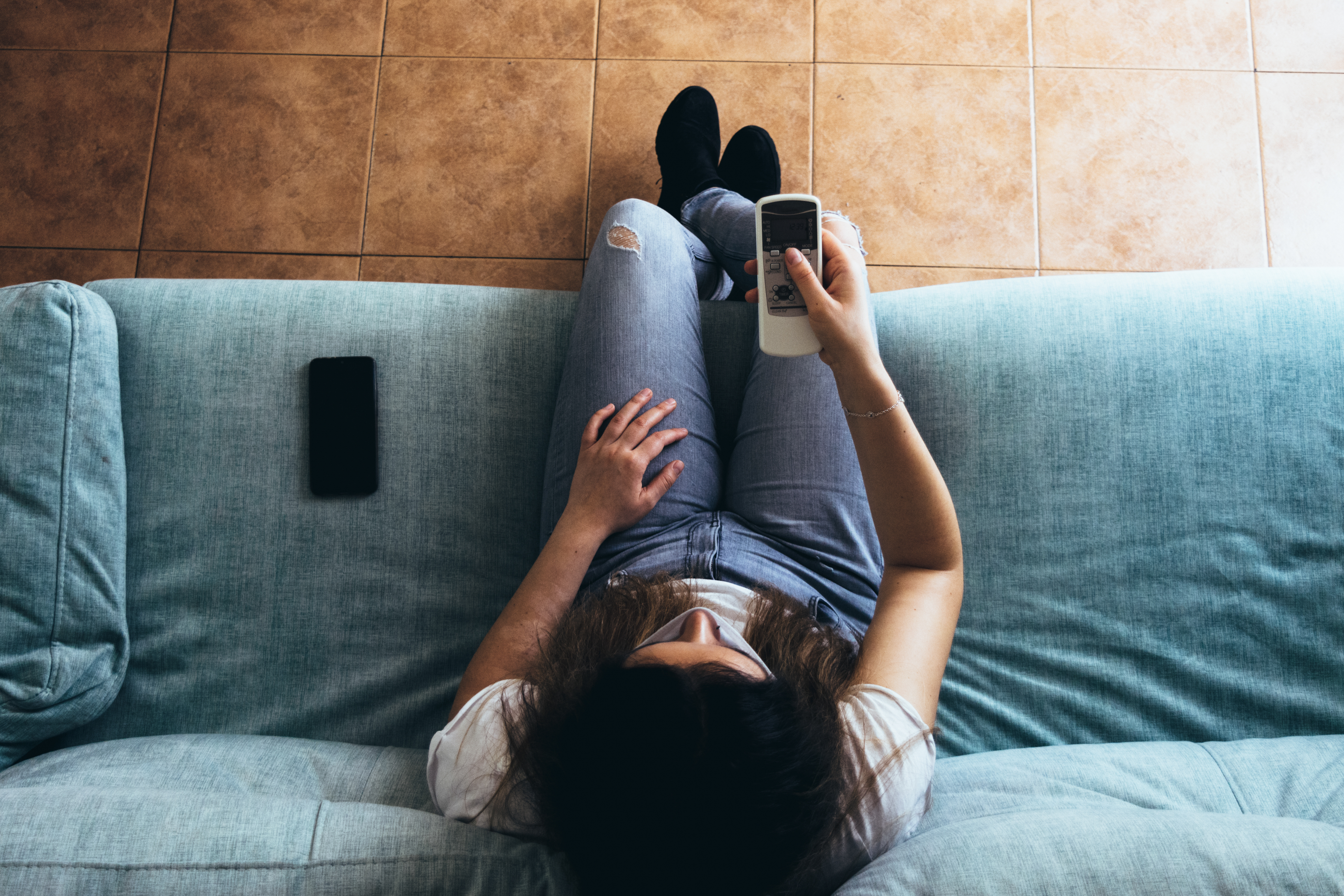 a woman lying on a couch looking at a cell phone