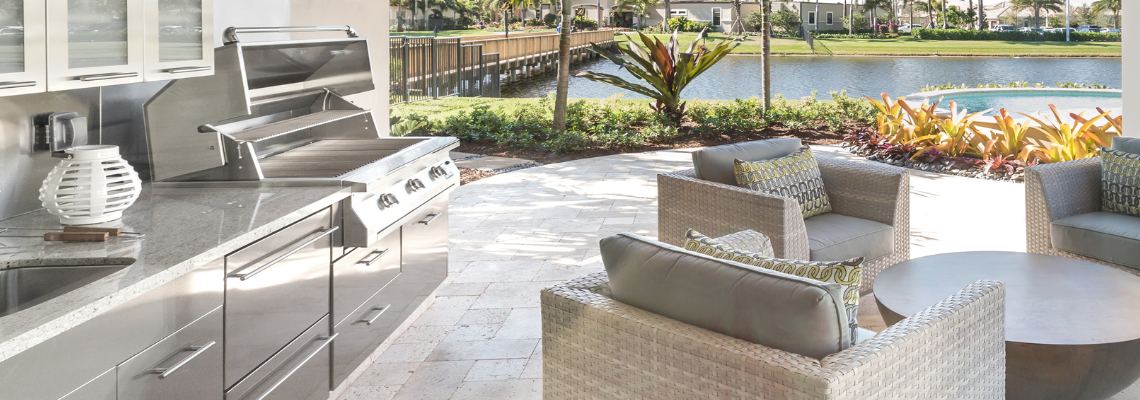 a patio with a grill and chairs