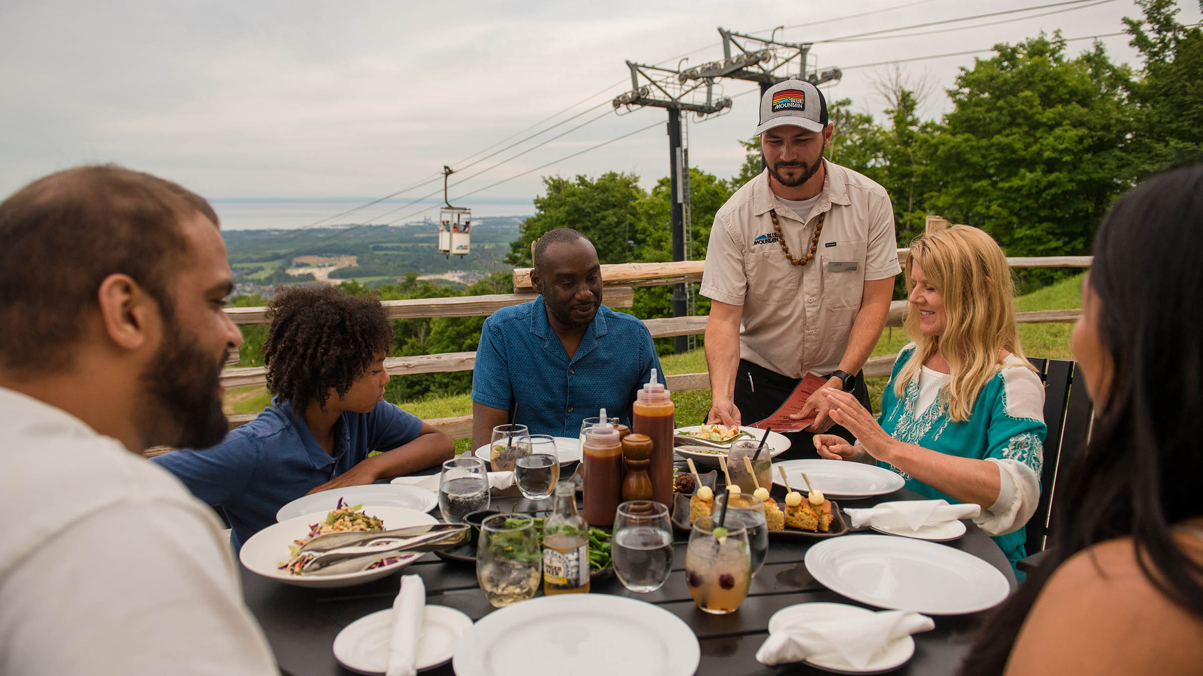 a group of people sitting at a table with food and drinks