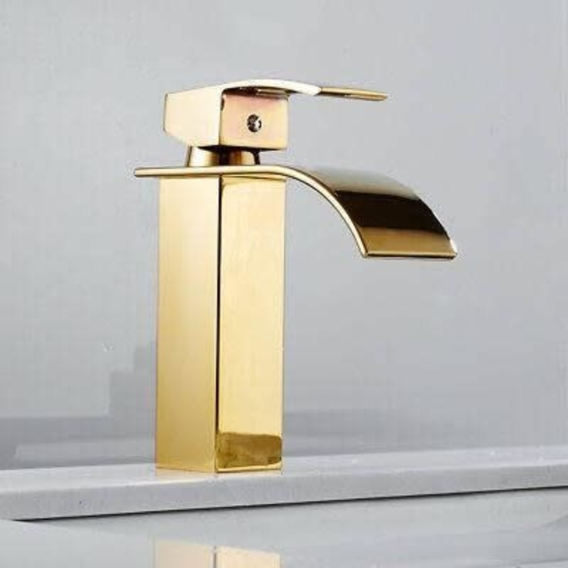 a gold faucet on a white counter