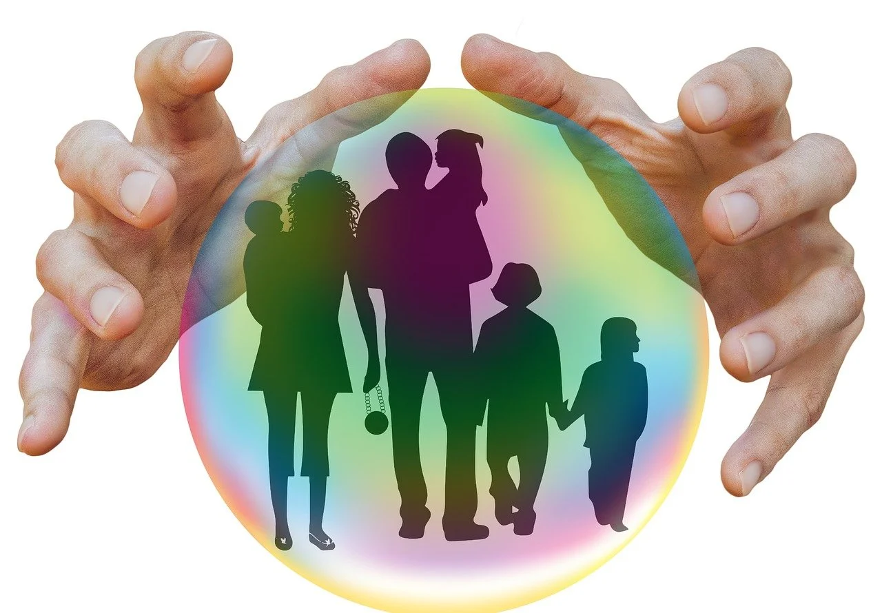 a person's hands holding a bubble with a family silhouette