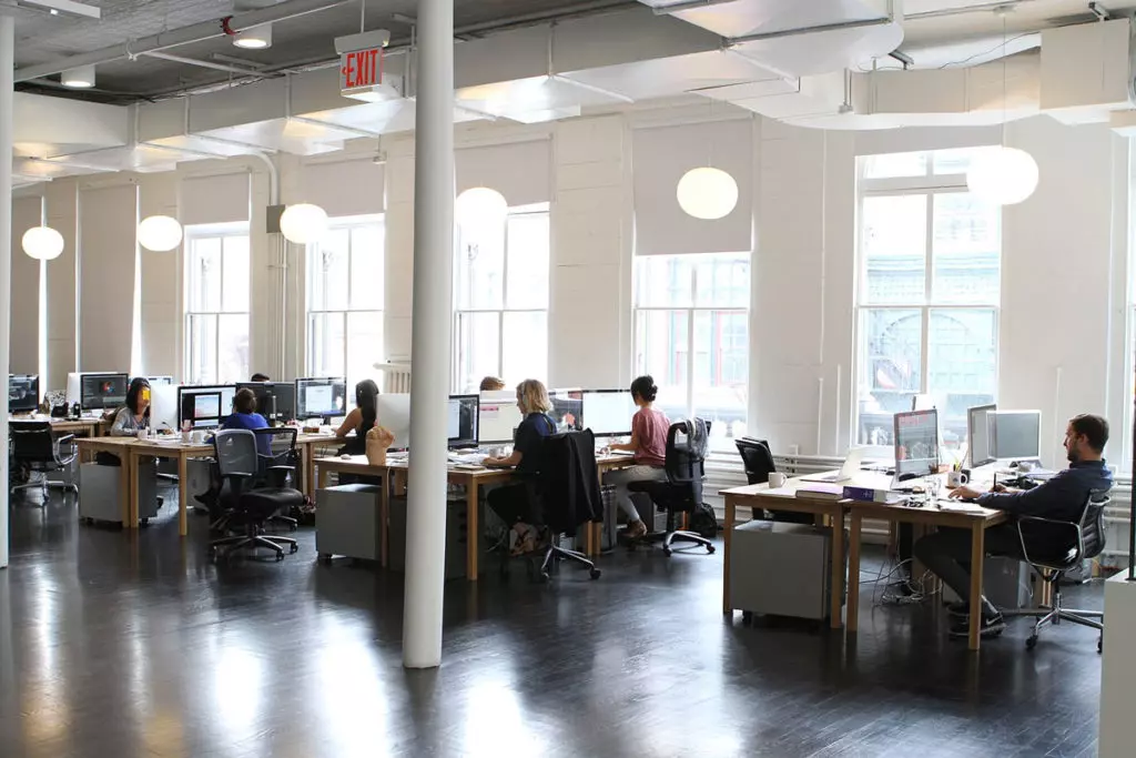 a group of people sitting at computers in an office