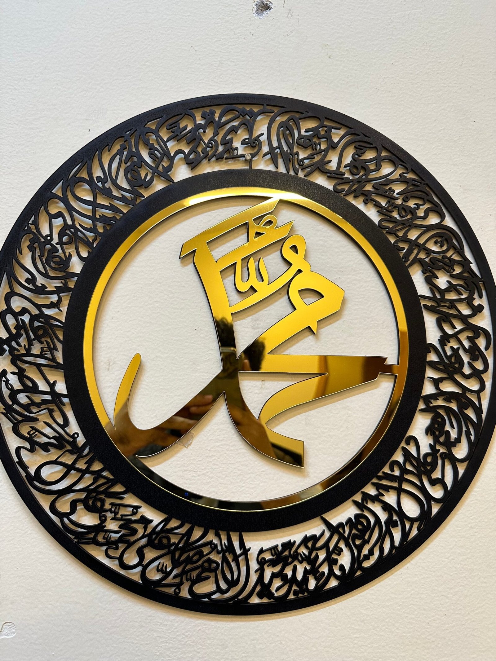 a circular black and gold sign