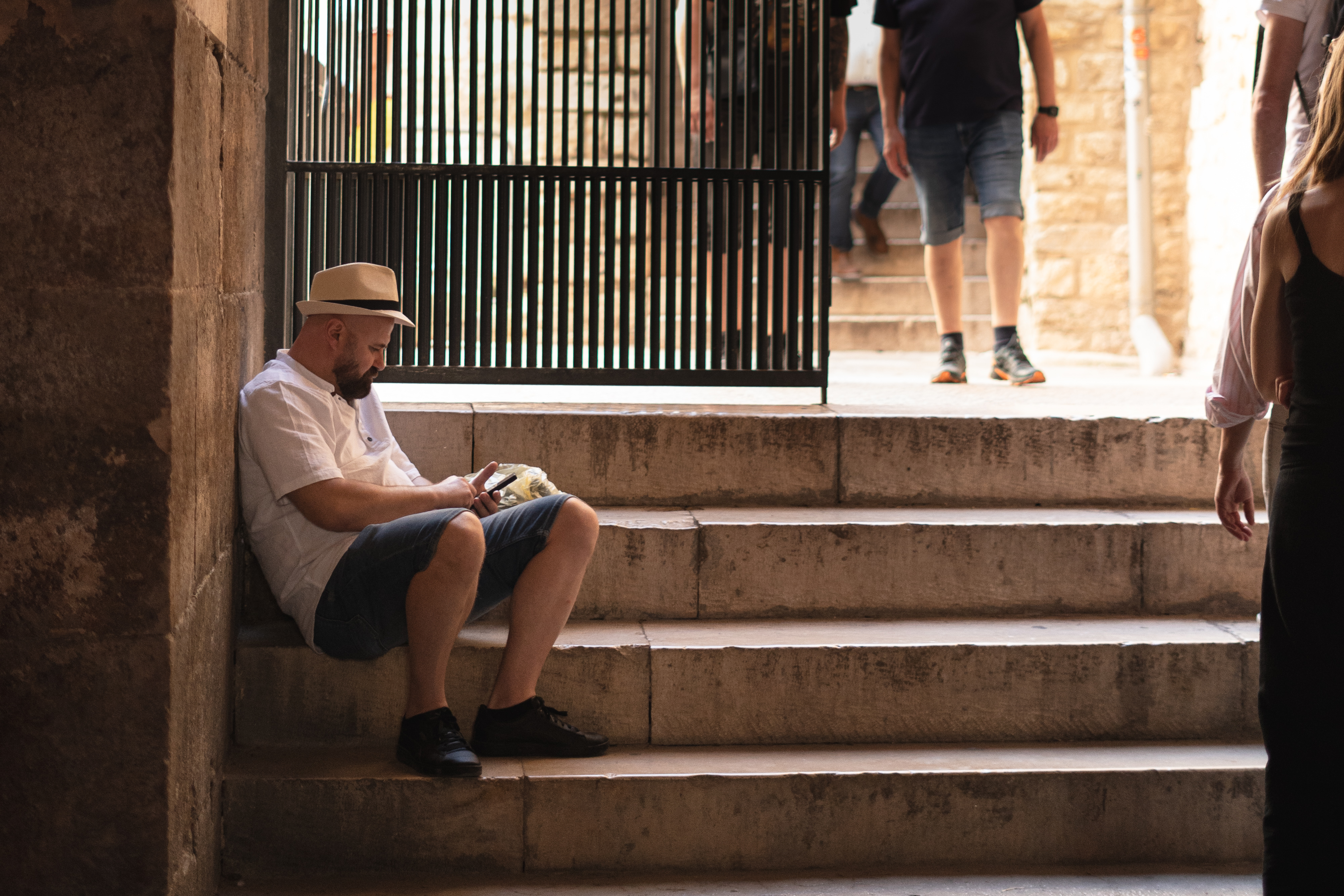 a man sitting on stairs looking at his phone