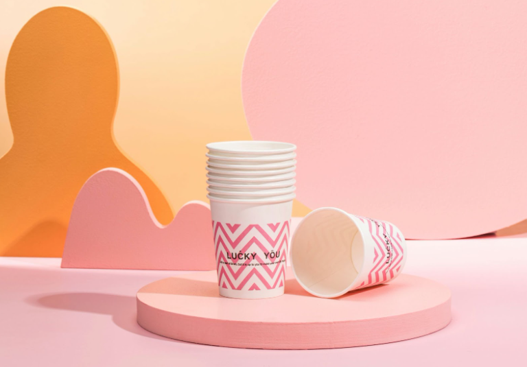 a stack of white cups on a pink stand