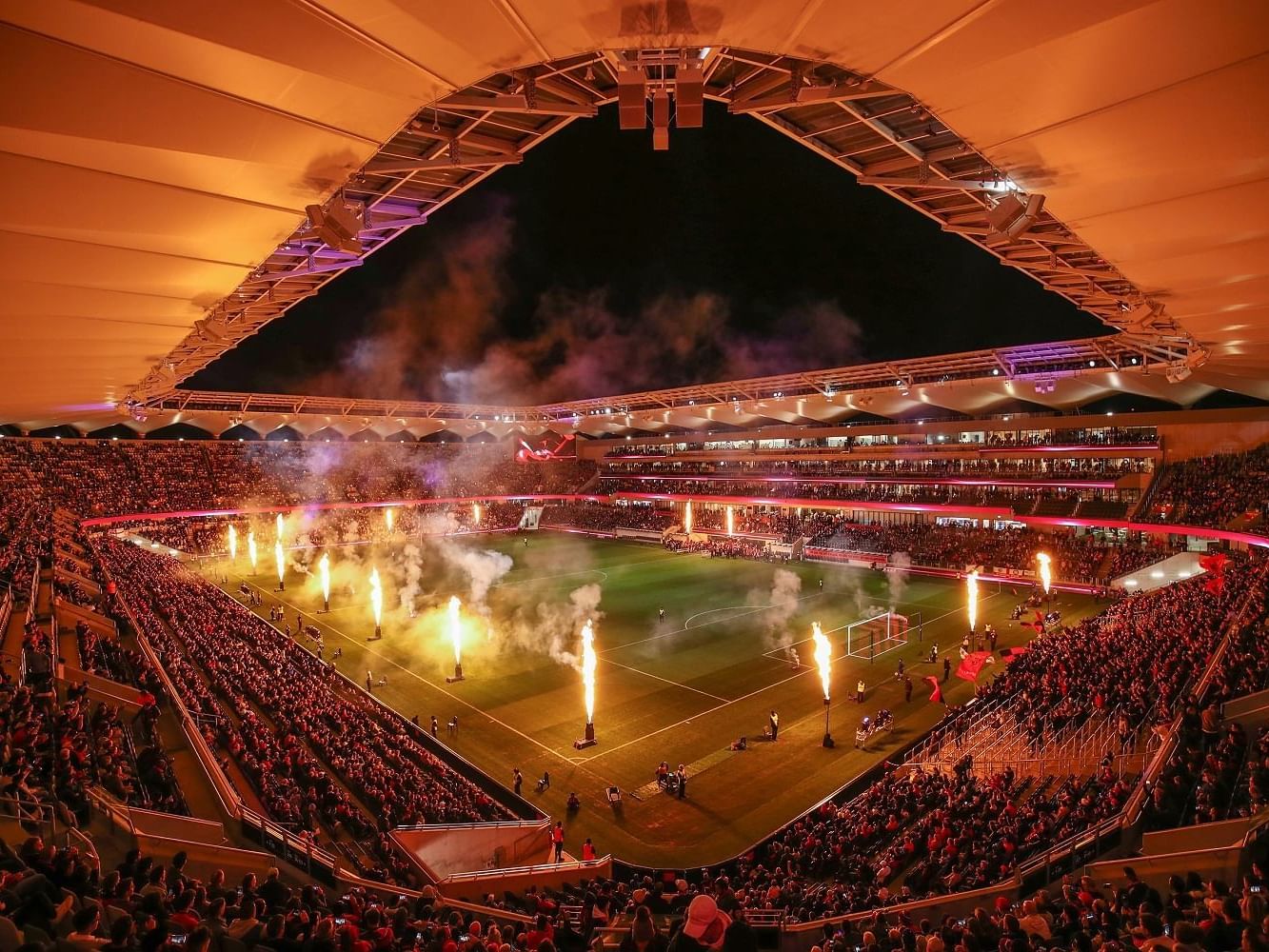 a stadium with a football field and fireworks