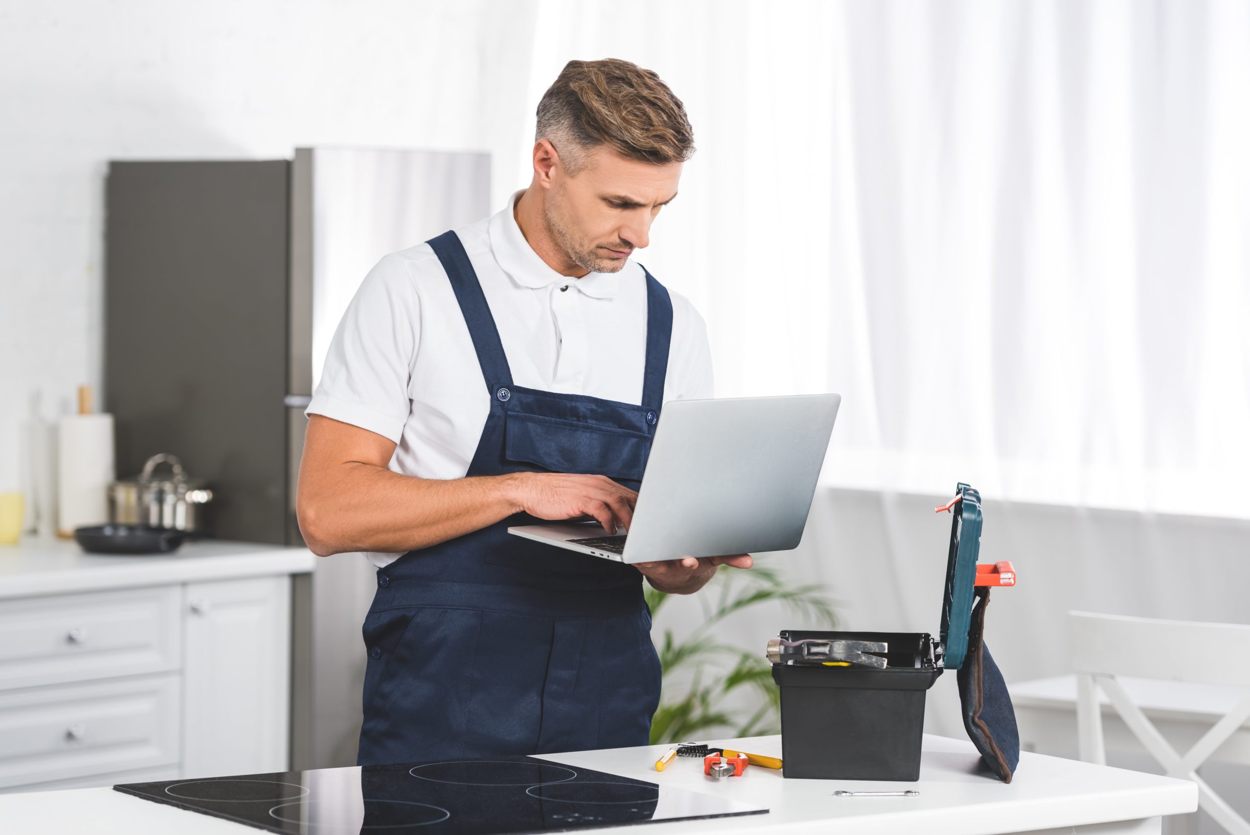 a man in overalls holding a laptop