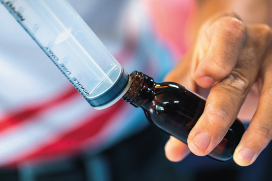 a hand holding a small bottle