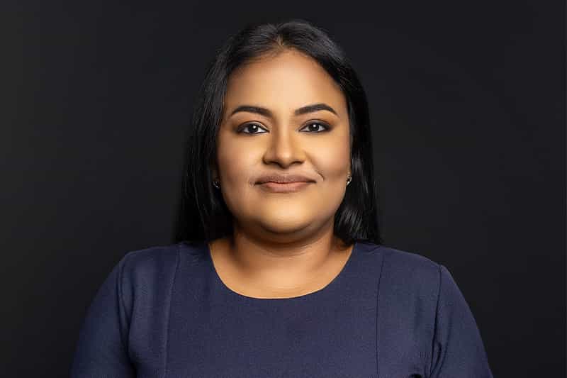 a woman with dark hair wearing a blue shirt