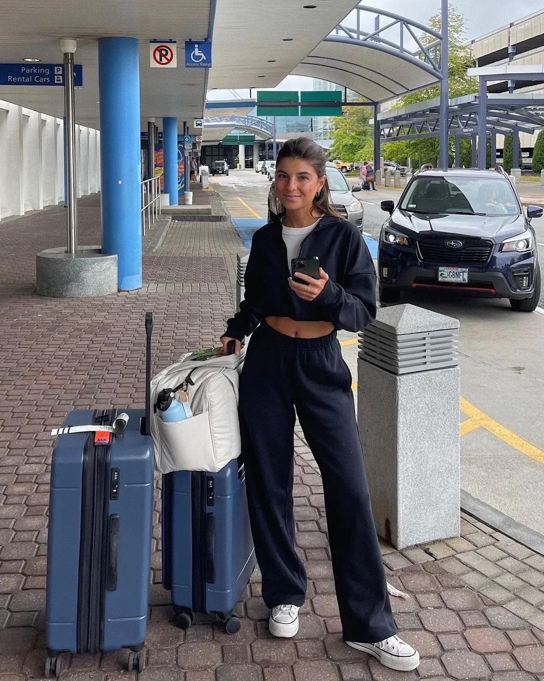 a woman standing outside with luggage