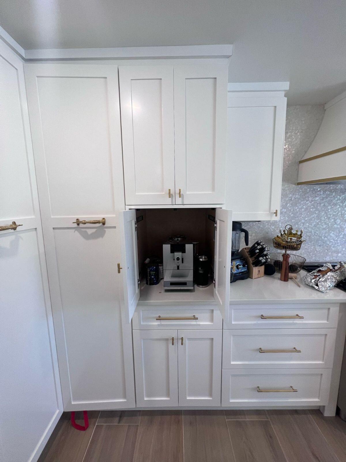 a white kitchen with a small open cabinet