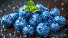 a pile of blueberries with leaves