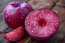 a cut plum with water droplets on it