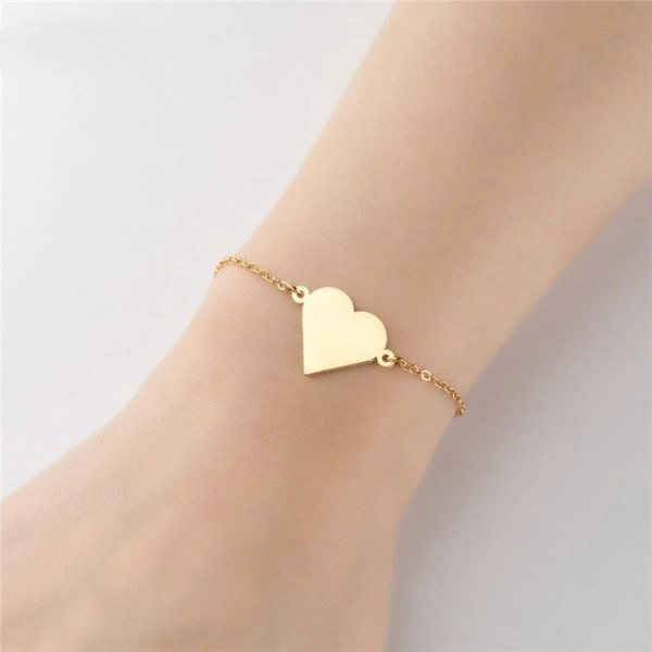 a gold heart bracelet on a wrist