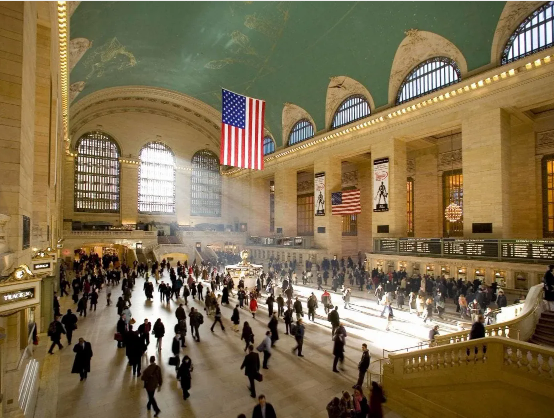 a large crowd of people in a large building with Grand Central Terminal in the background