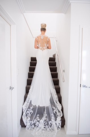 a woman in a white dress walking up stairs