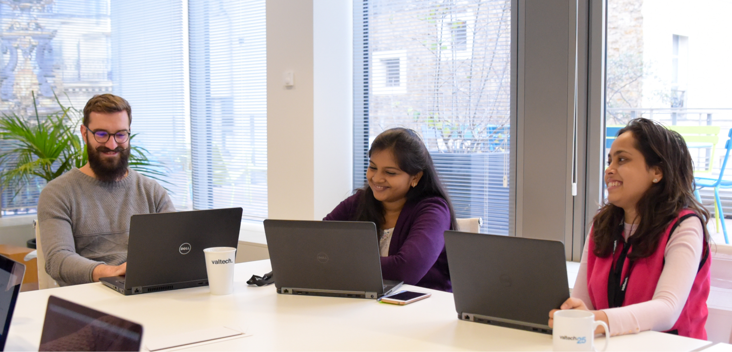 a woman sitting at a table with laptops