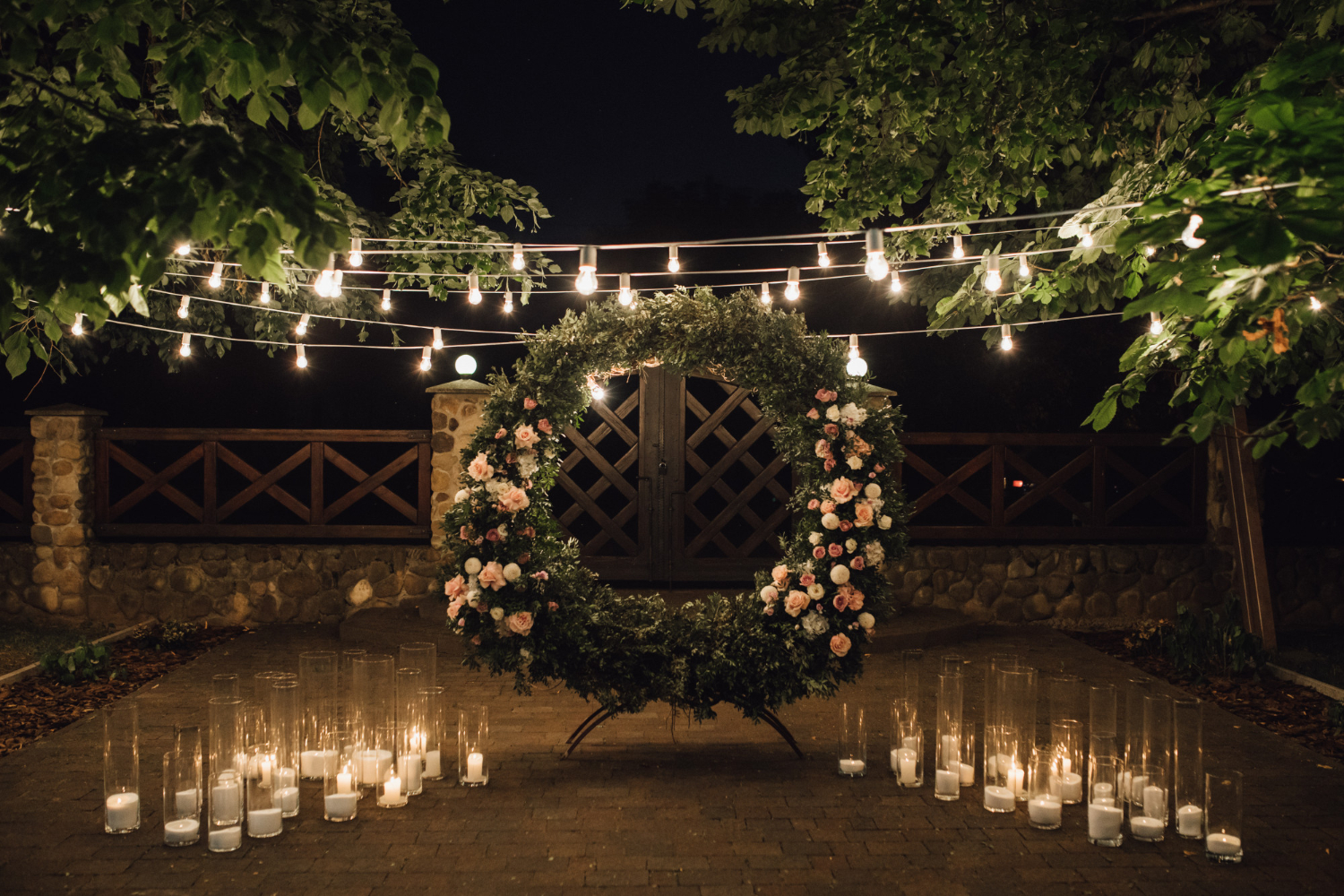 a wreath with flowers and candles in front of a door