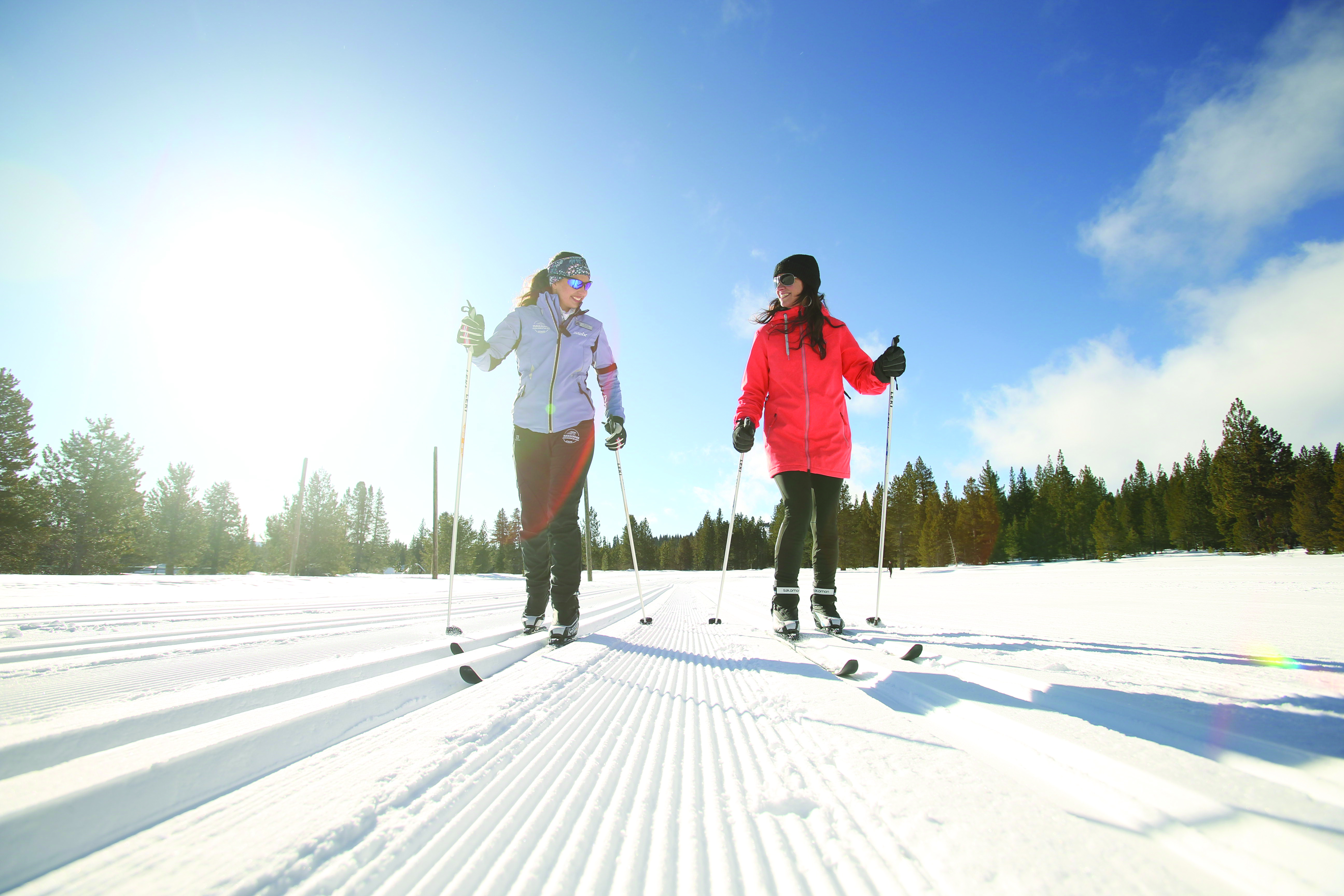 two women on skis on a snowy slope