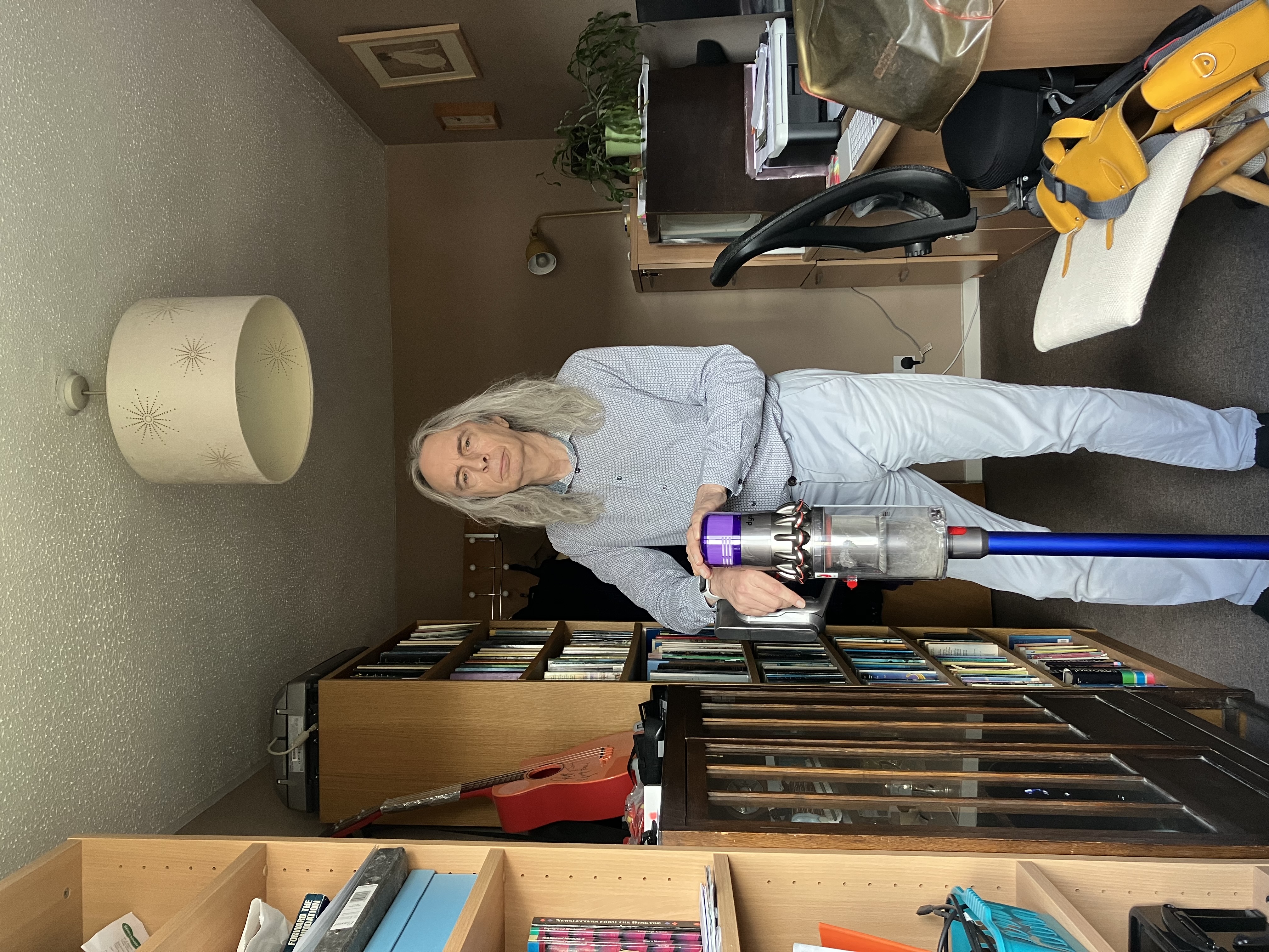 a man standing in a room with a vacuum cleaner