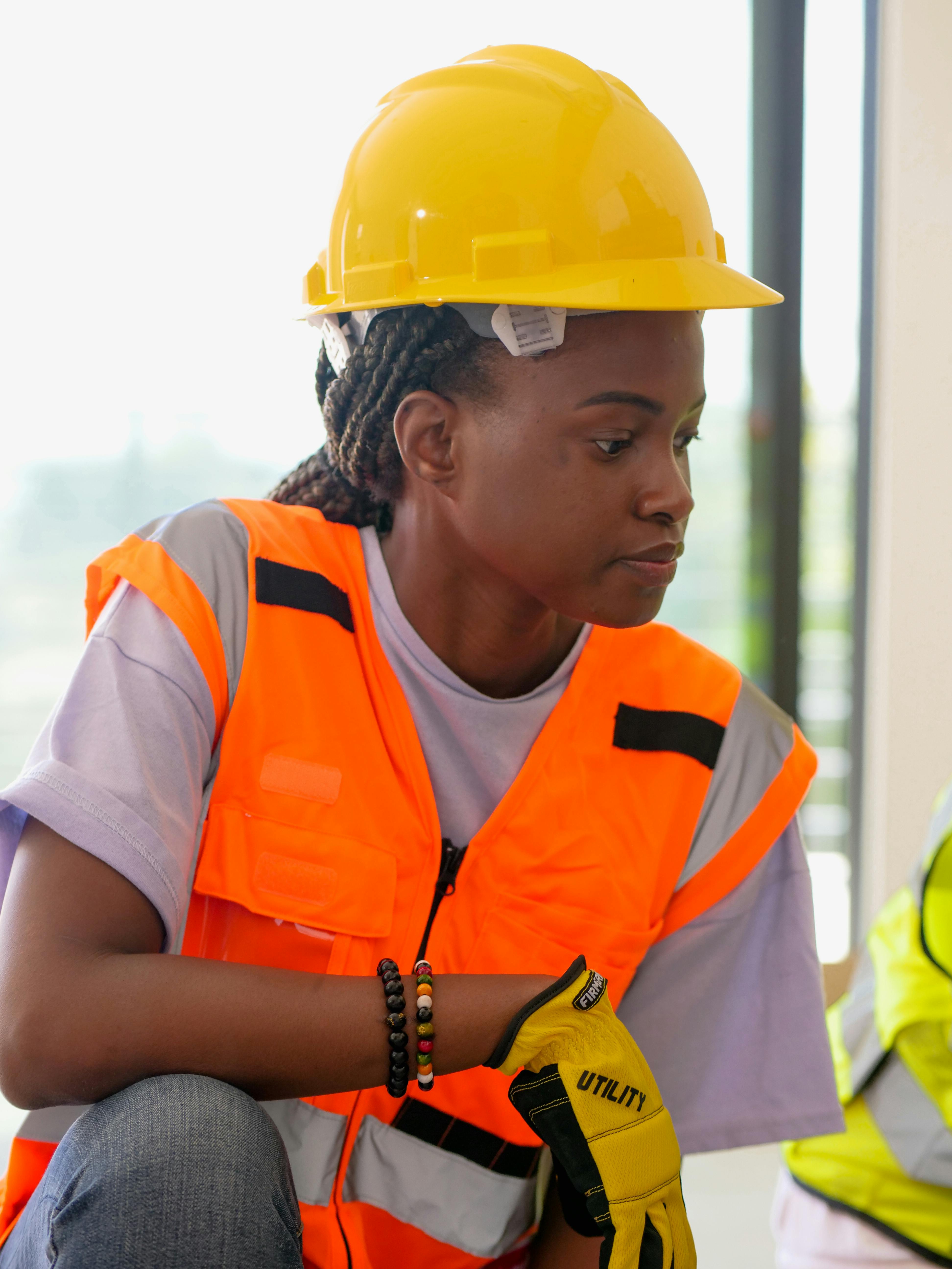 a woman wearing a yellow hard hat and orange vest