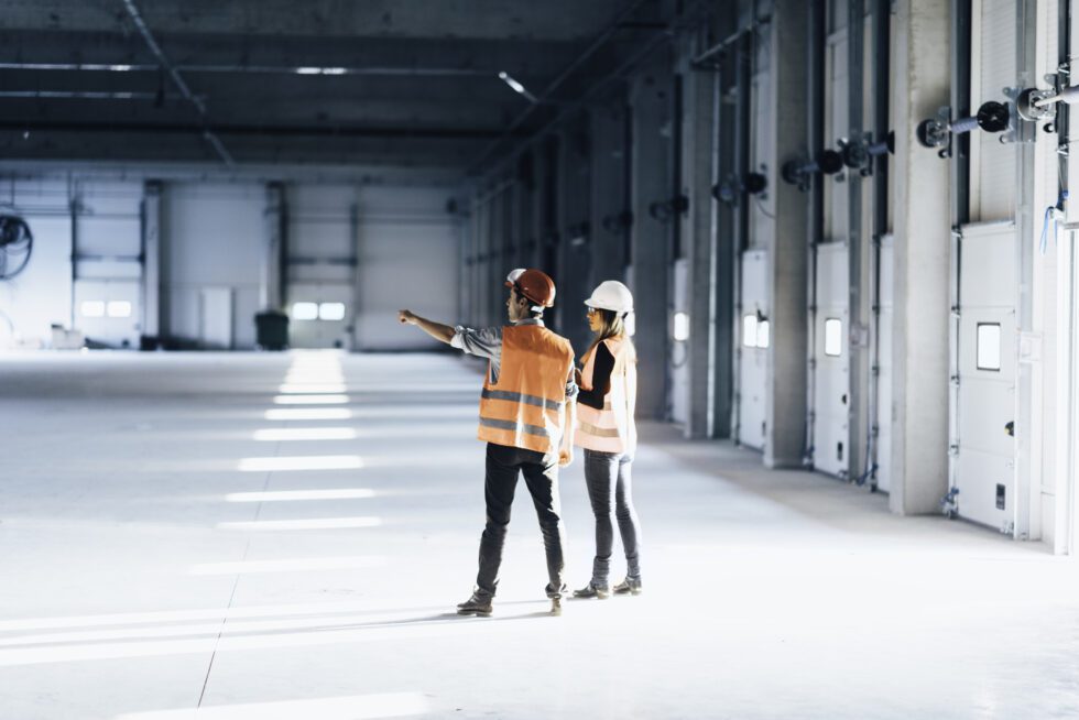 a man and woman wearing helmets and vests in a large room