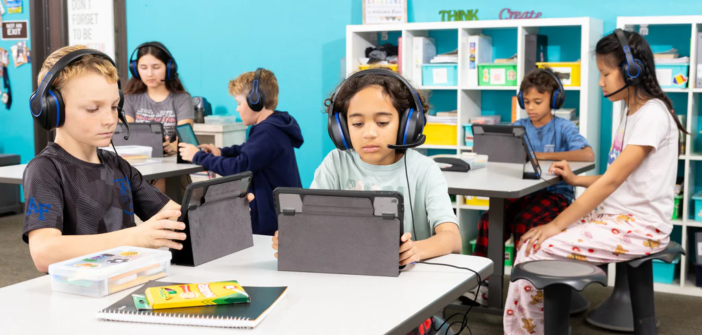 a child wearing headphones and using a tablet