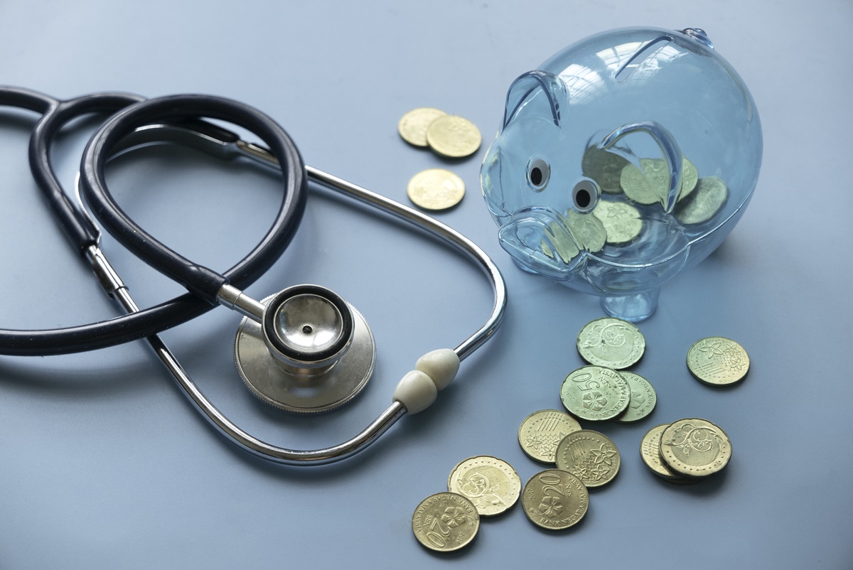 a stethoscope next to a piggy bank