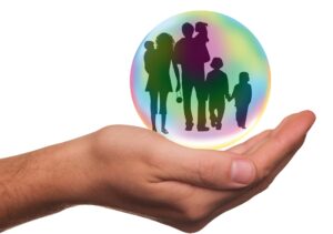 a hand holding a bubble with a family silhouette