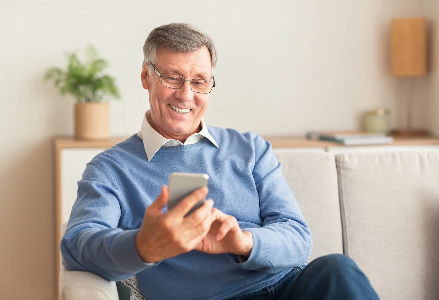 a man sitting on a couch looking at a phone