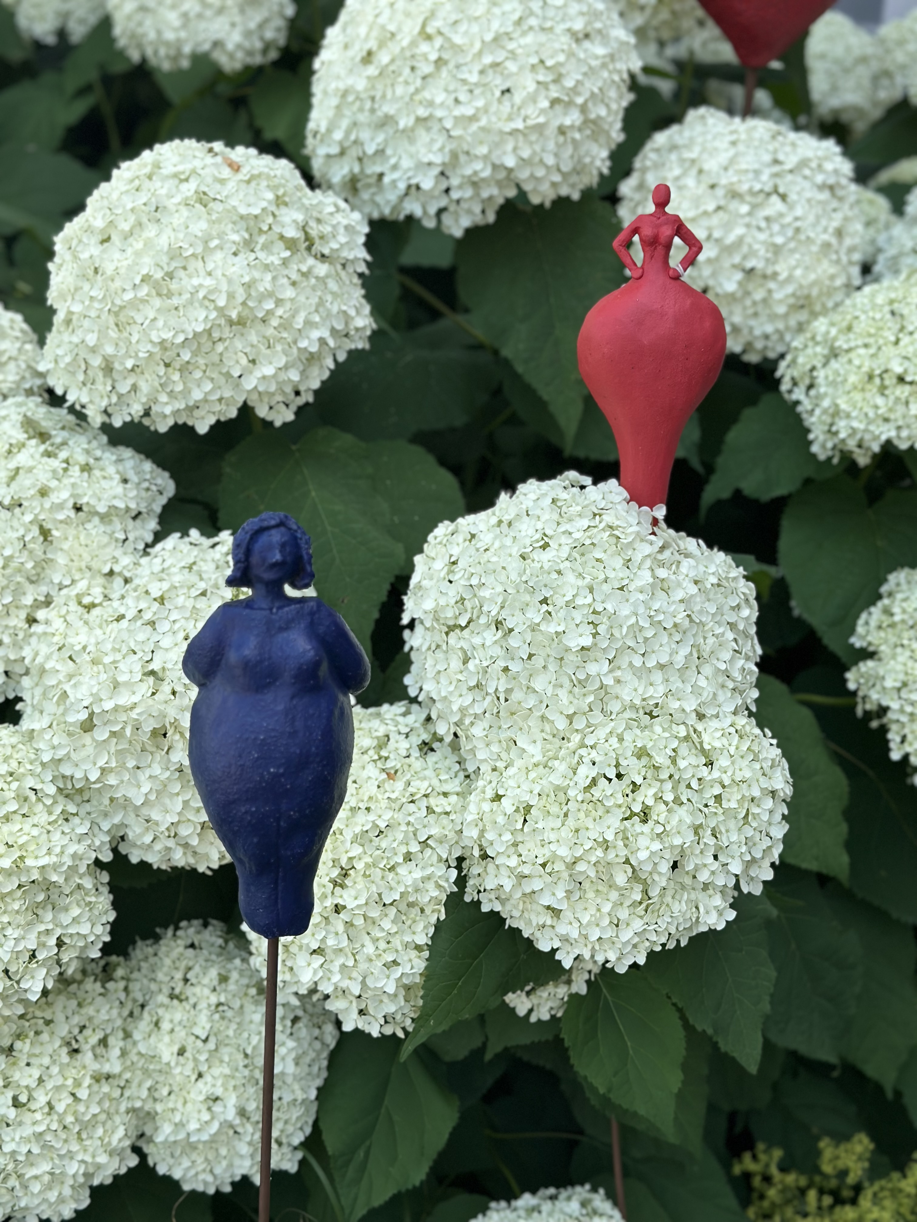 a blue and red figurines on a white flower