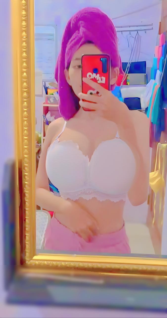 a mirror selfie of a woman with purple hair