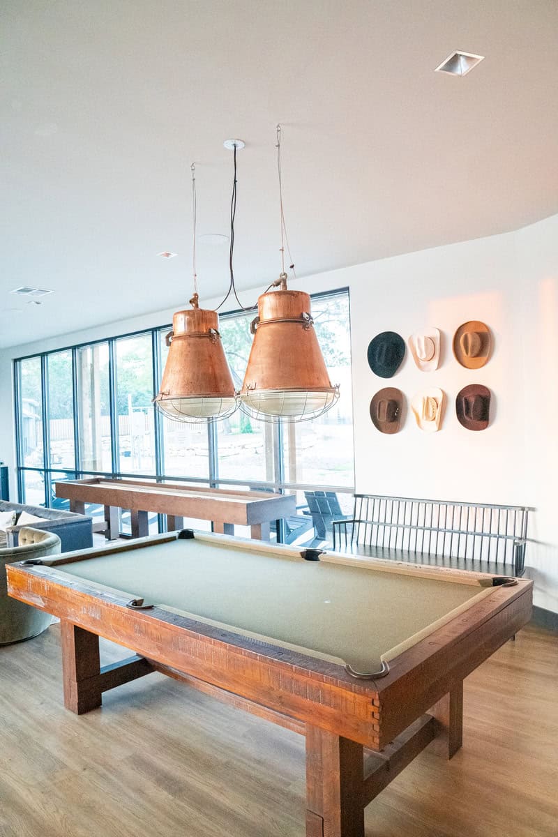 a pool table with two lights from the ceiling